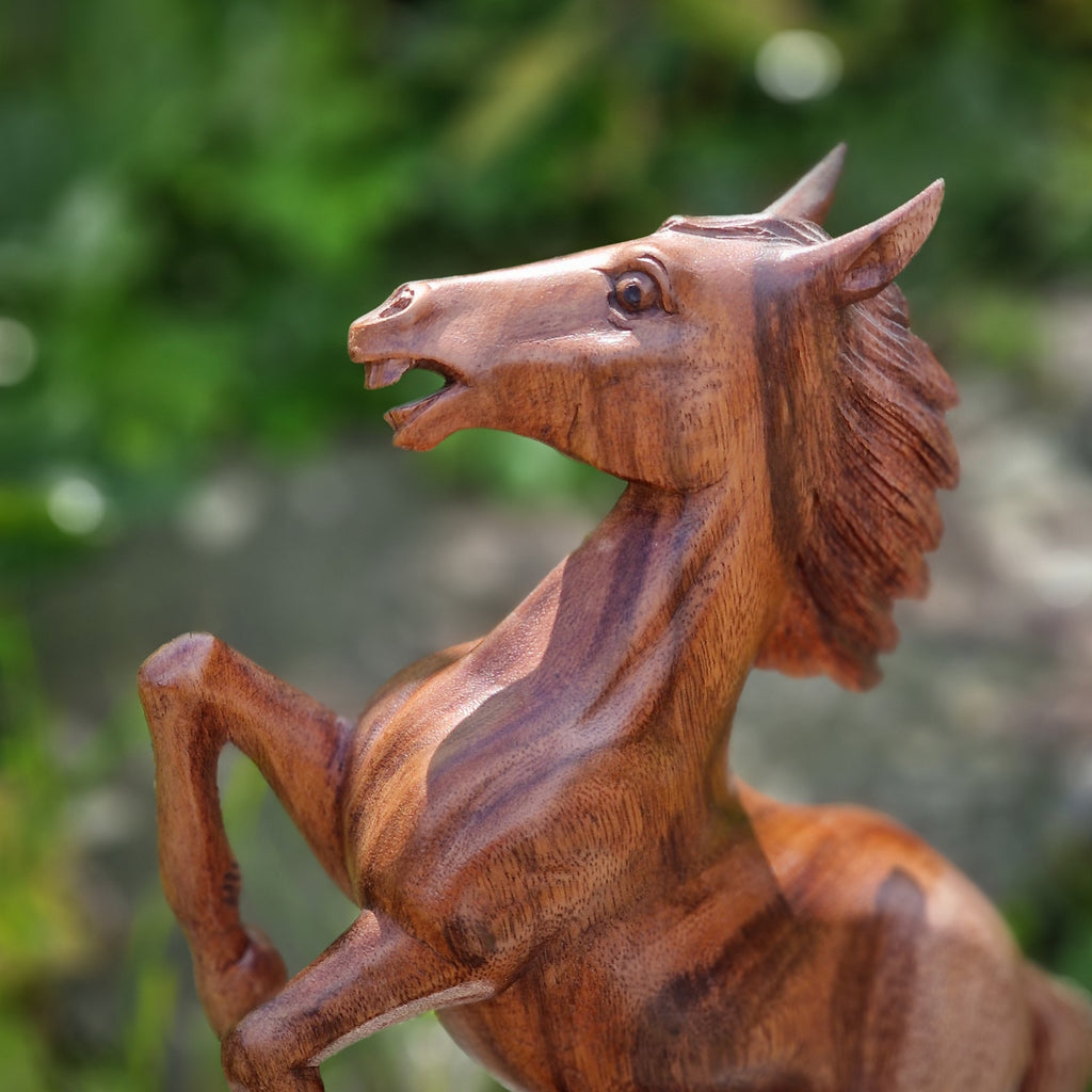 Pferde Statue aus Holz auf Stein mit grünem Hintergrund